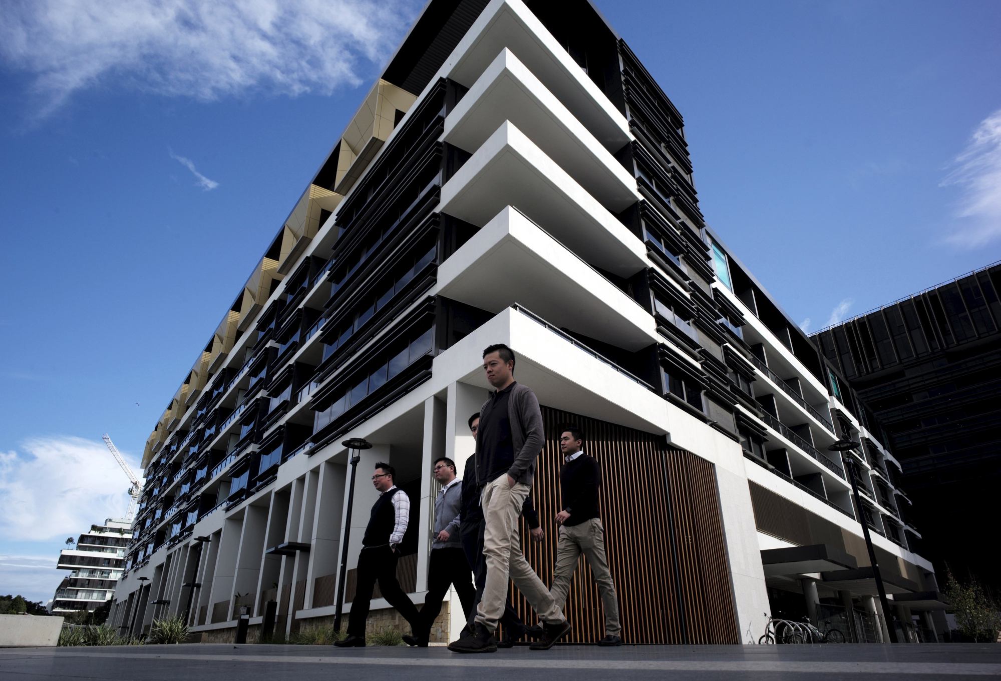 Sydney residents walk past an apartment development in Sydney’s inner-city suburb of Zetland. Photo: Reuters