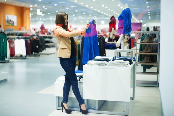 A female shopping for clothes off a display.