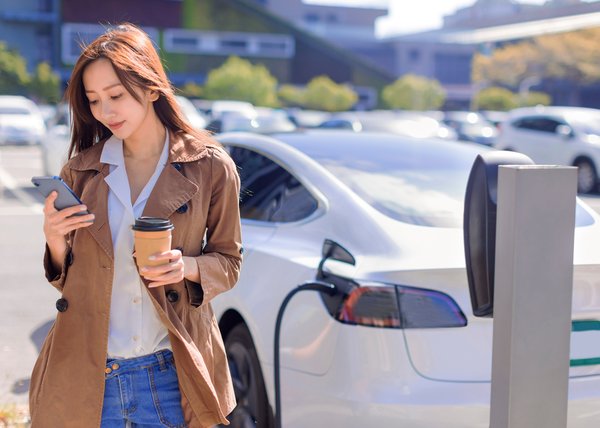 A driver waits for an electric vehicle to charge.