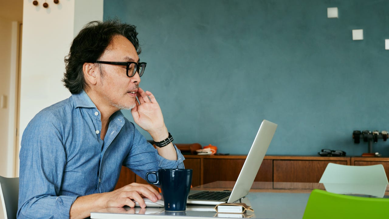 Man working on laptop and drinking coffee