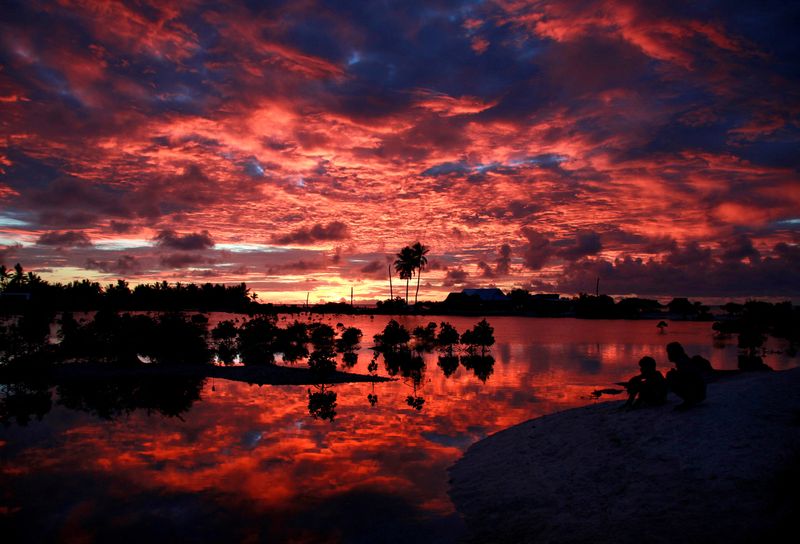 © Reuters. FILE PHOTO: Villagers watch the sunset over a small lagoon near the village of Tangintebu on South Tarawa in the central Pacific island nation of Kiribati May 25, 2013.  REUTERS/David Gray/File Photo