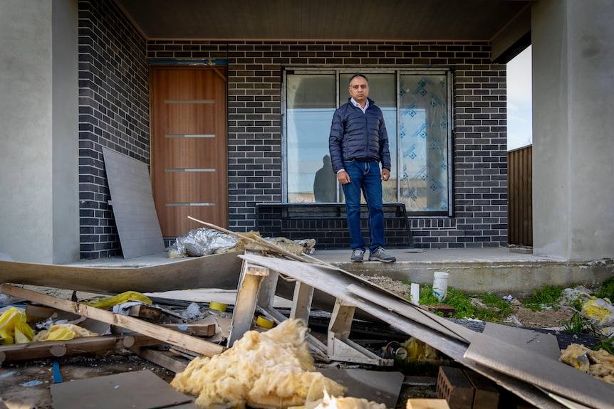 Surya Kant looks at the front yard of his house which is covered in construction materials.