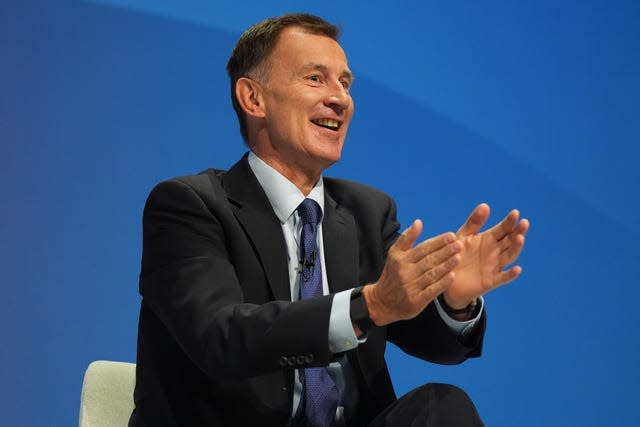 Jeremy Hunt smiles as he gestures with his hands