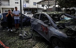 People stand near a damaged car at a site of houses damaged following a rocket attack from Lebanon, amid cross-border hostilities between Hezbollah and Israel, in Kiryat Bialik, Israel. (Photo: Reuters)