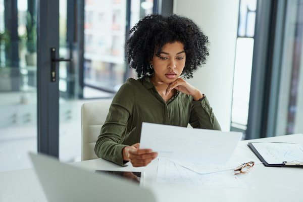 Shot of a person going over paperwork in a modern office.