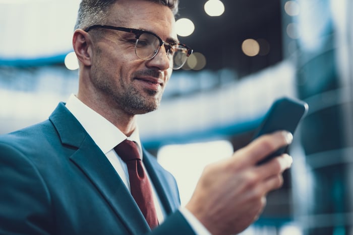 Man looking at his phone smiling.