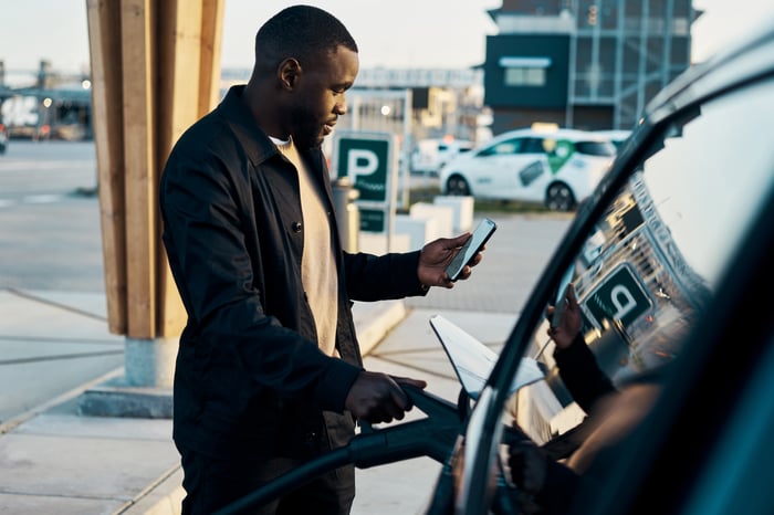 A person charges an EV at a charging station.