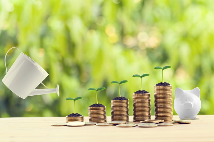 Plants sprouting from stacks of coins.