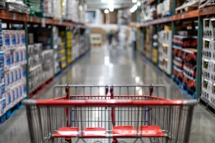 An empty shopping cart in a retail setting store aisle. 