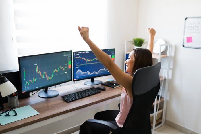 Person looking at graphs and charts happy because the stock market went up.