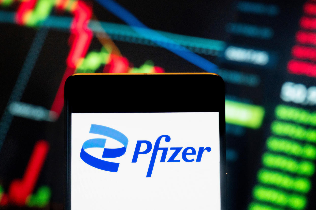 CHINA - 2024/06/21: In this photo illustration, the American multinational pharmaceutical corporation Pfizer (NYSE: PFE) logo seen displayed on a smartphone with an economic stock exchange index graph in the background. (Photo Illustration by Budrul Chukrut/SOPA Images/LightRocket via Getty Images)