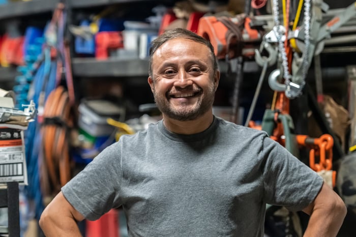 Smiling person in hardware store, with hands on hips.