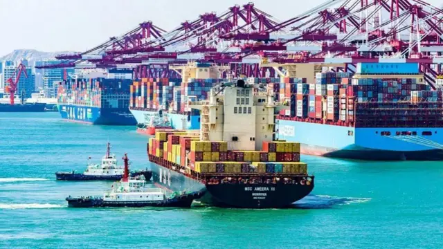 A cargo ship piled high with containers sails from Qingdao Qianwan Container Terminal in Qingdao.