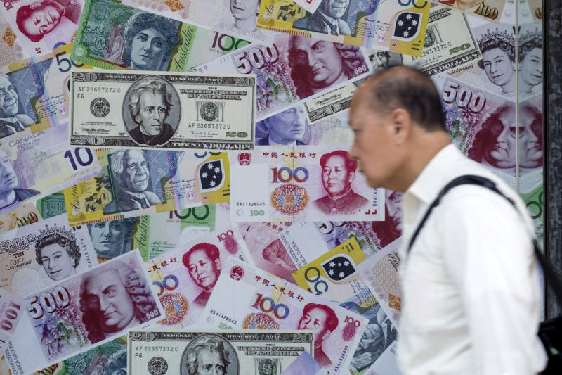 A man walks past an advertisement promoting China's yuan, US dollar and Euro exchange services at foreign exchange store in Hong Kong on Aug 13, 2015. (Photo: Reuters)