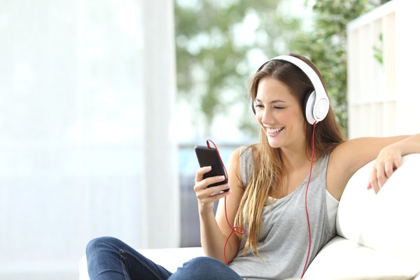 Someone listening to music on their smartphone through headphones.