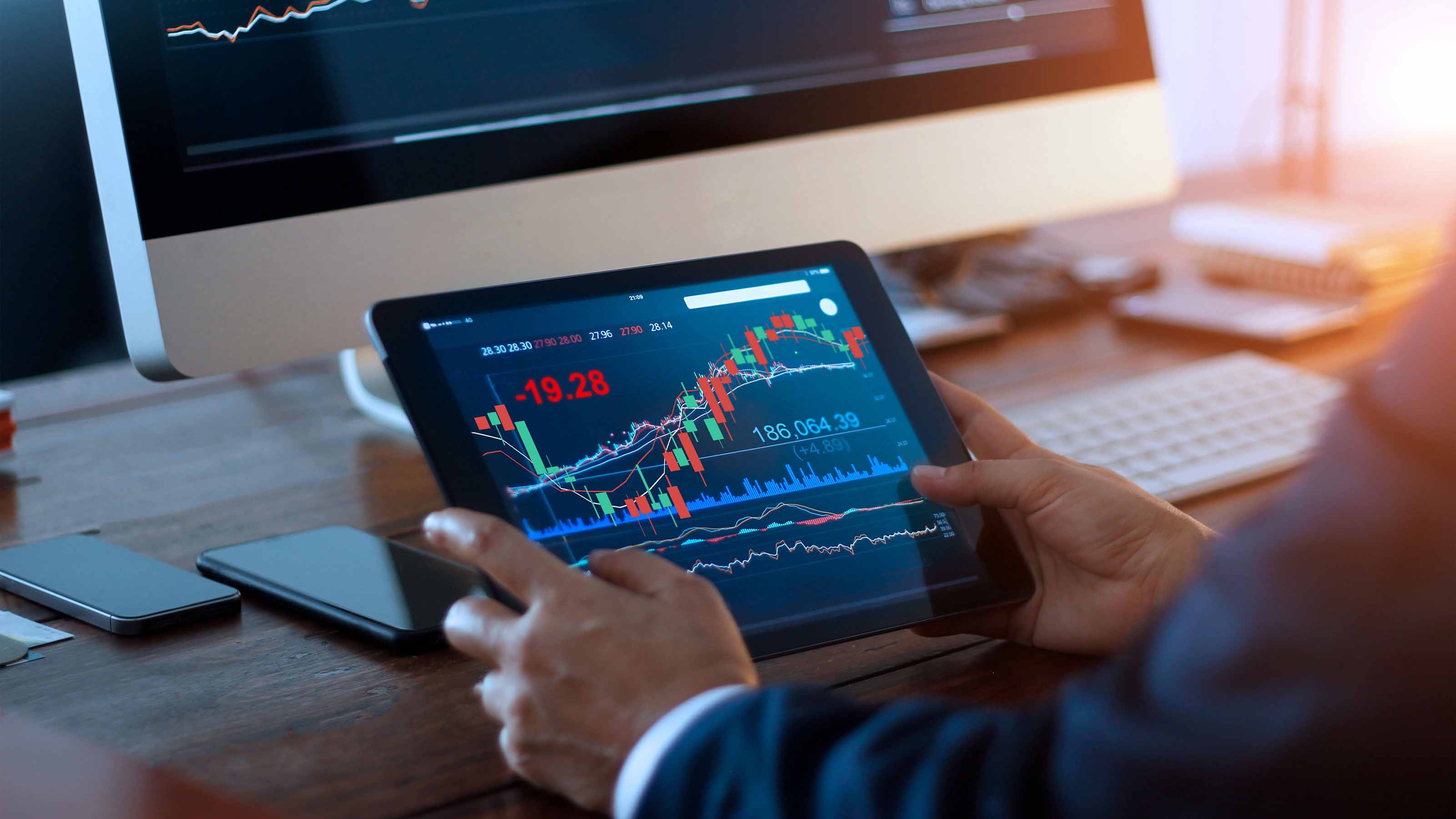 An investor looking at charts on a tablet.