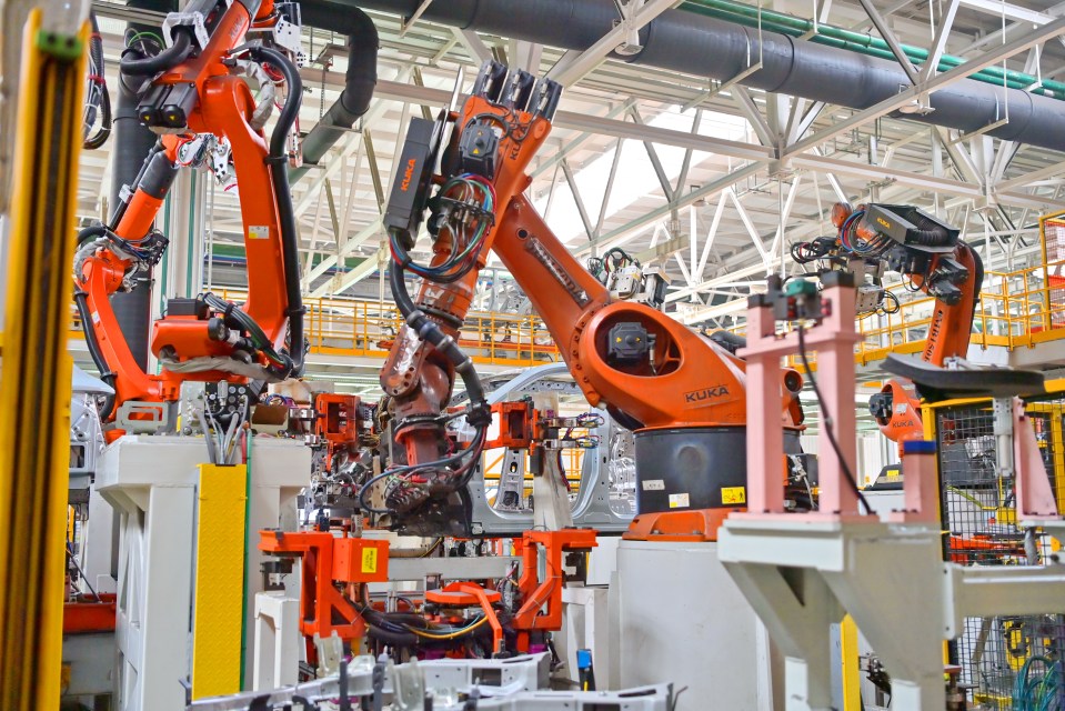 Robotic arms assembling car parts on a factory assembly line.