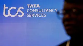 FILE PHOTO: A man walks past a logo of Tata Consultancy Services (TCS)