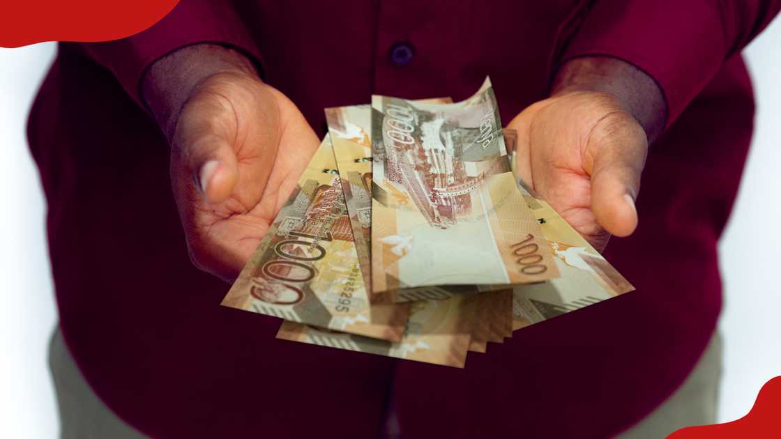 A man holds Kenyan banknotes. A man holds Kenyan banknotes.