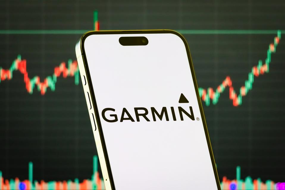 Garmin Ltd. logo on smartphone with stock market chart background
