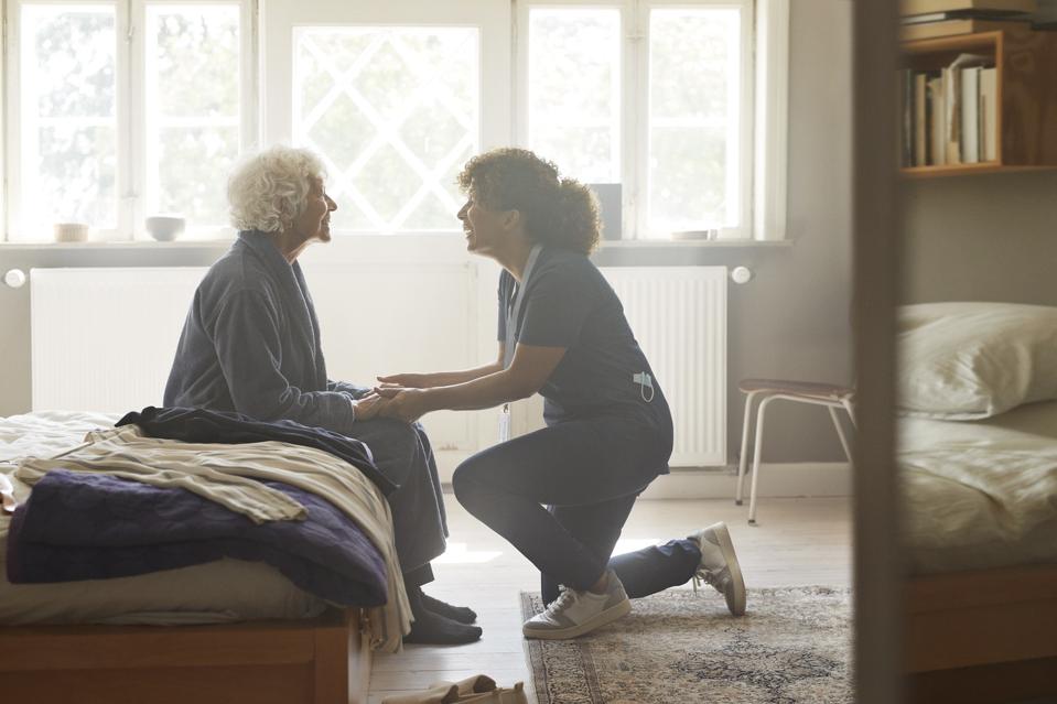 Caregiver holding hands of senior woman