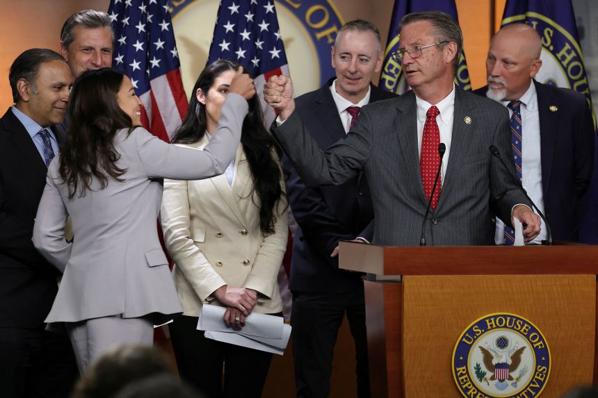 Rep. Alexandria Ocasio-Cortez shares a fist bump with Rep. Tim Burchett at a news conference with a bipartisan group of House members saying they are prepared to force a vote on legislation to ban members of Congress and their families from trading stocks, on Capitol Hill on September 3, 2025.