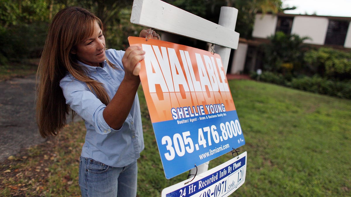 Realtor with for sale sign