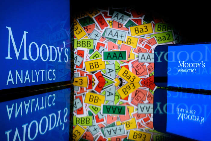 This illustration photograph shows screens displaying the logo of the rating agency Moody's Analytics and signs of the ratings used by rating agencies, in Toulouse on March 18, 2025.