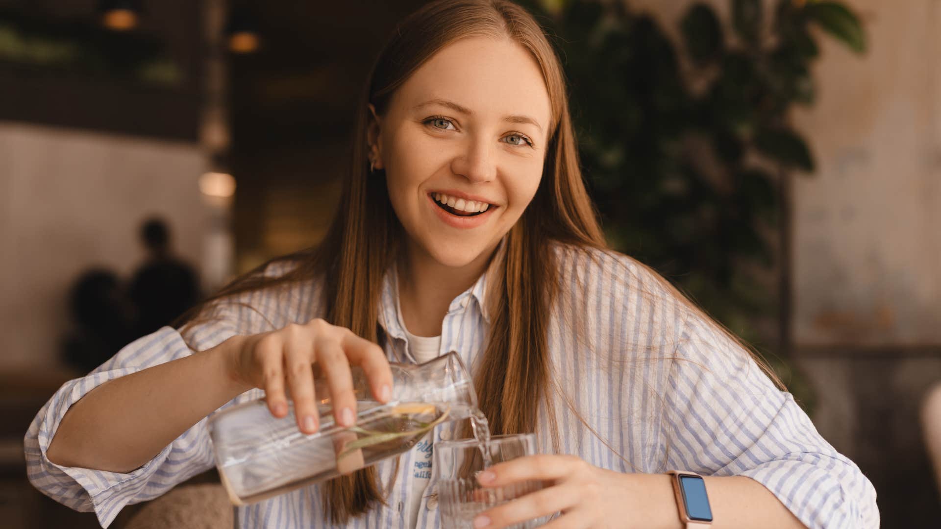 woman drinking water at a restaurant to save money