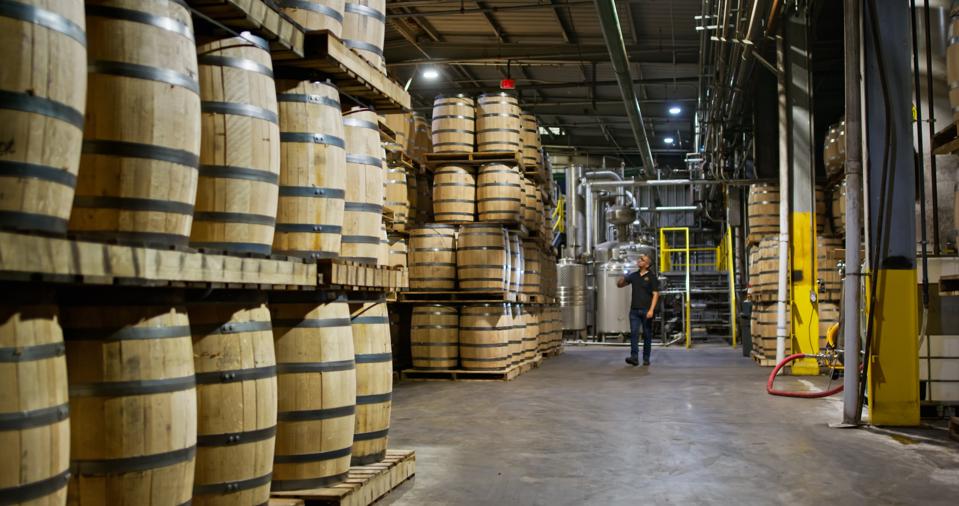 Wide Shot of Distillery Owner Inspecting Barrels in his Warehouse