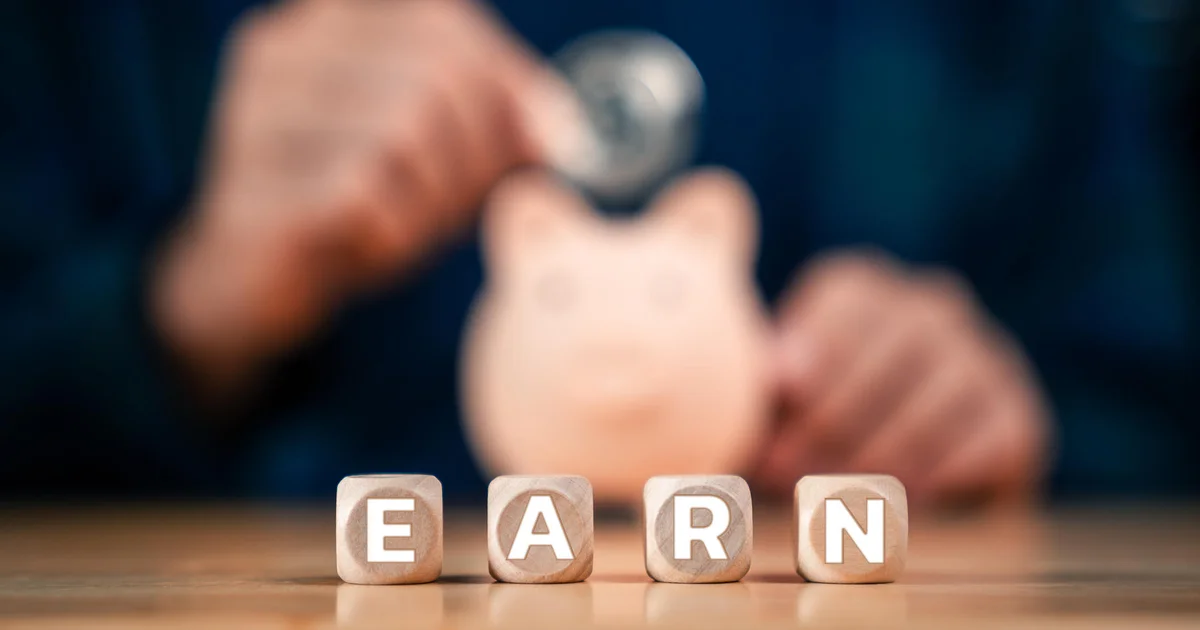 Saving Money, Piggy Bank and Investment Planning with Close-Up of Hand Putting Coins into Piggy Bank 