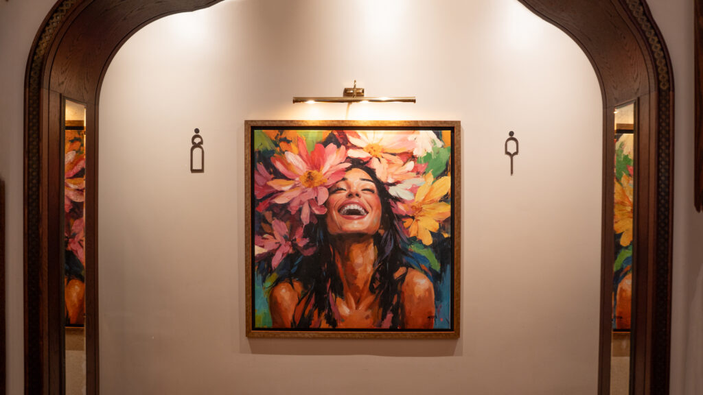 Colourful Gabrielle Malak portrait surrounded by flowers at La Maison Ani