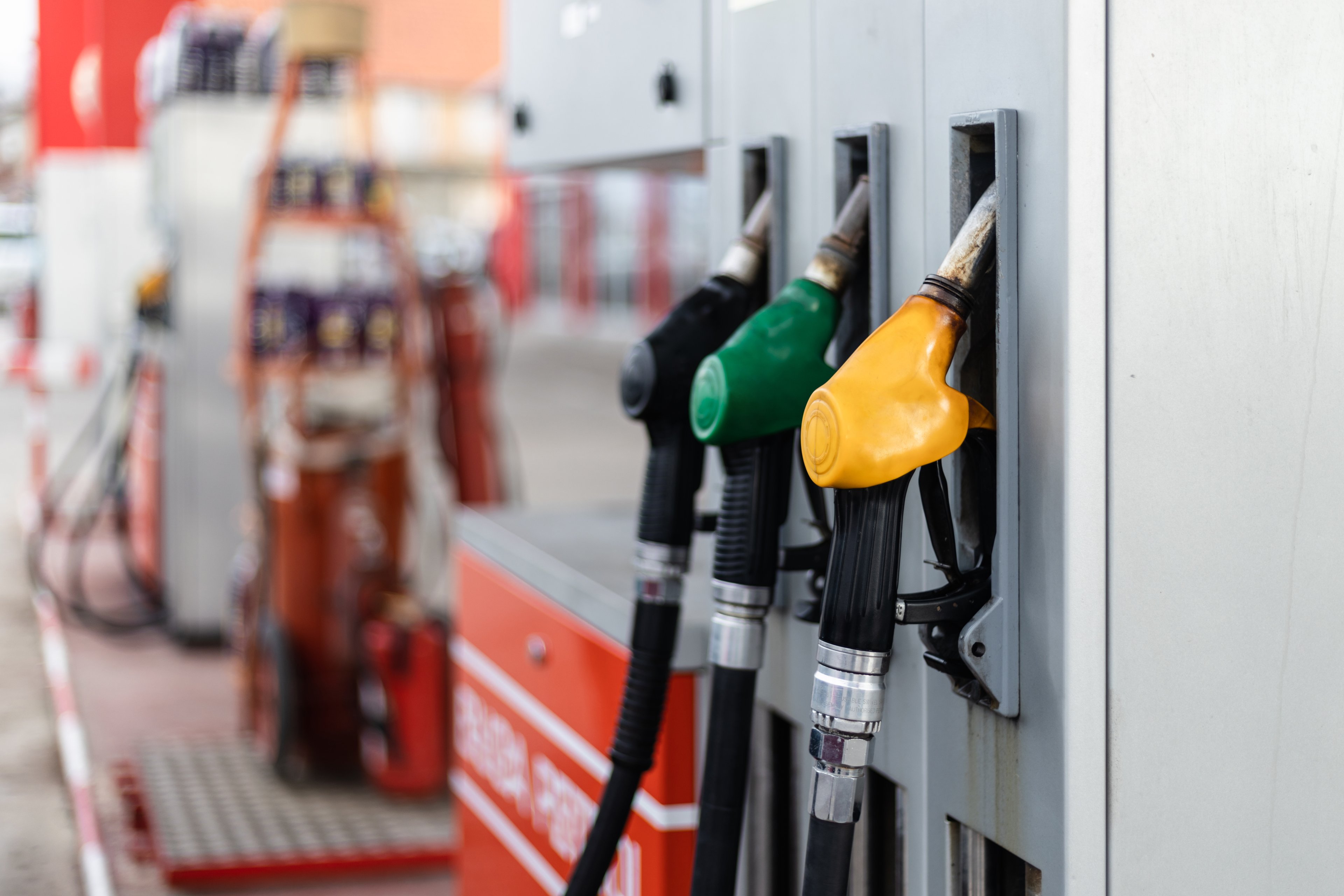 Three gas pumps are shown at a gas station.