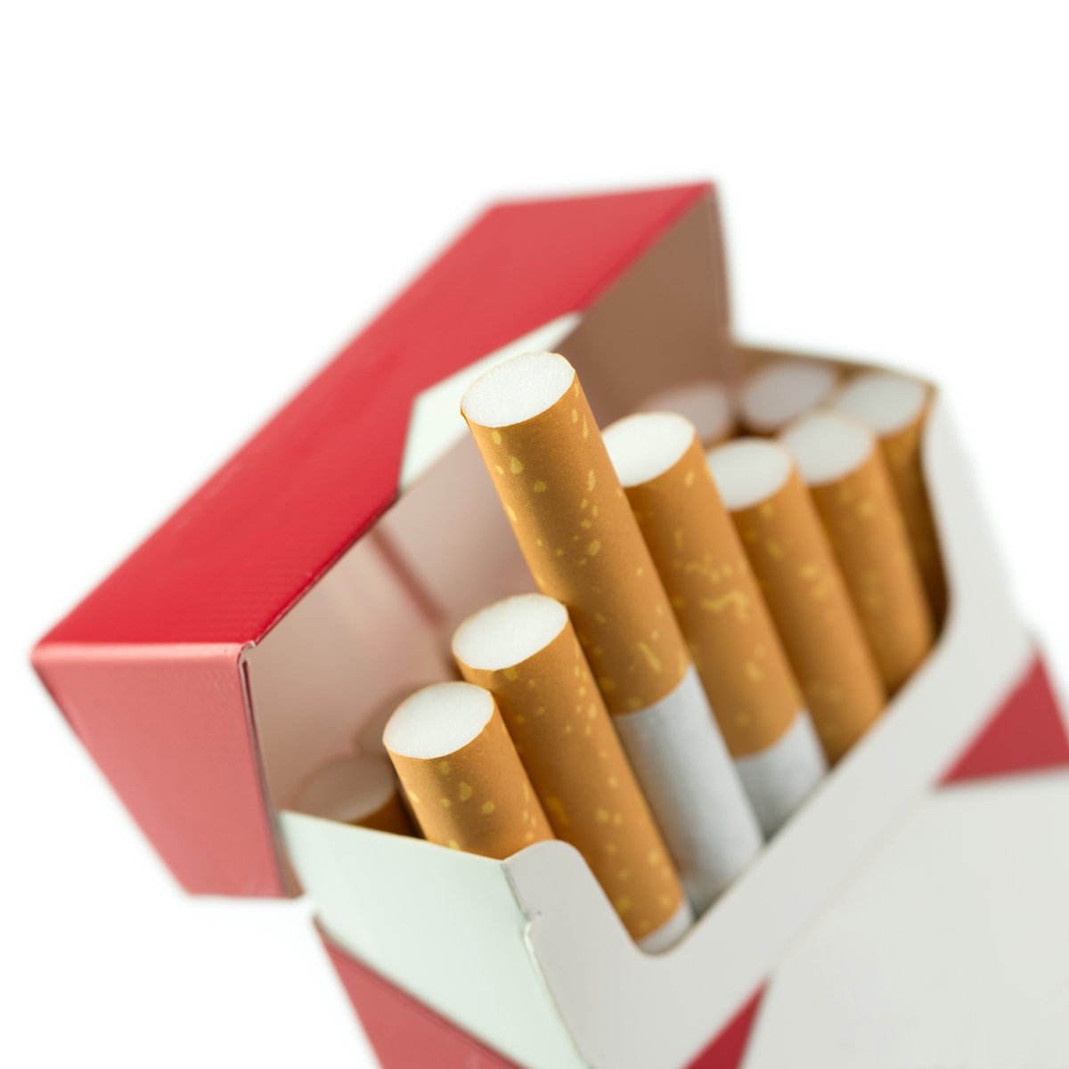 Individual cigarettes stick out of an open flip-top cigarette pack.